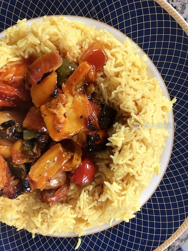 中国食物的形象，甜酸鸡和酱汁/健康的糙米煮姜黄照片，在盘子里